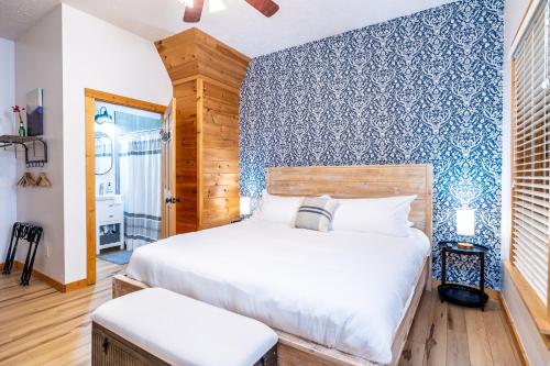 a bedroom with a bed and a blue wall at SmokiesBoutiqueCabins would love to host you! 4 miles to Gatlinburg Strip! Resort Pool open May 1 through Oct 1! Views, Shuffleboard, Hot Tub, Arcade! in Gatlinburg