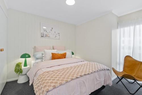 1 dormitorio blanco con 1 cama y 1 silla en Luxurious riverfront villa with dreamy water views, en Montagu Bay