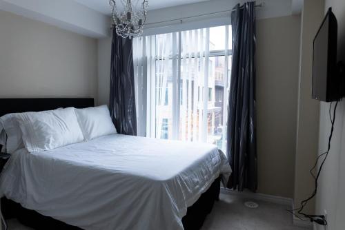 ein Schlafzimmer mit einem Bett und einem großen Fenster in der Unterkunft The Tranquil Retreat in Toronto
