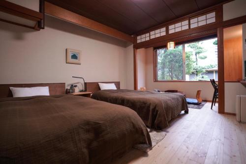una camera con due letti e una finestra di Ryokan Marumo a Tottori