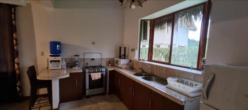 a kitchen with a sink and a stove and a window at Valles de Olon, Lugar encantador y acogedor para un feliz descanso. in Santa Elena