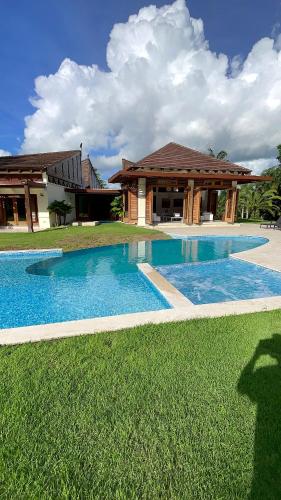 a large swimming pool in front of a house at SrvittiniVillas Spacius Confort Villa Fam Team CouplesCasa de Campo Resort in La Romana