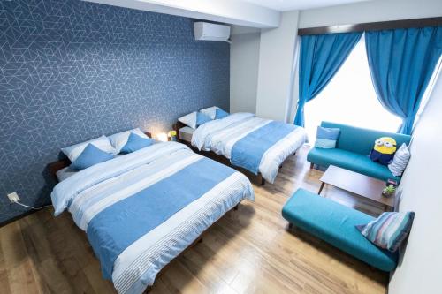 1 dormitorio con 2 camas y sofá en Lexia Nishikujo - Vacation STAY 15380, en Osaka
