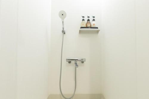 baño blanco con ducha con cabezal de ducha en Lexia Nishikujo - Vacation STAY 15380, en Osaka