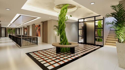 un vestíbulo con una planta en una mesa y escaleras en Posto Dormire Sudirman en Yakarta