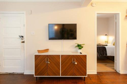 a room with a dresser with a tv on the wall at Classic & Cozy Apartments - Parking & Close To Dw in Medford
