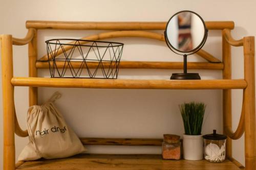 a shelf with a mirror and a bag on it at Classic & Cozy Apartments - Parking & Close To Dw in Medford