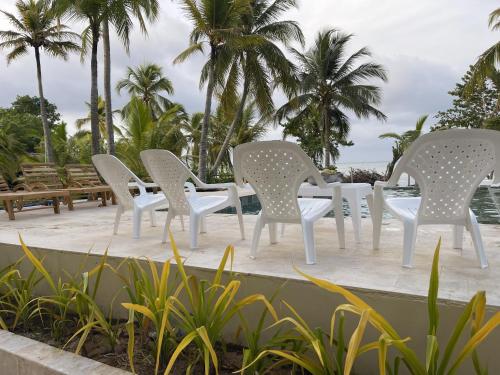 - un ensemble de chaises et de tables blanches sur une terrasse dans l'établissement Tubará Casa de Playa, à San Antero