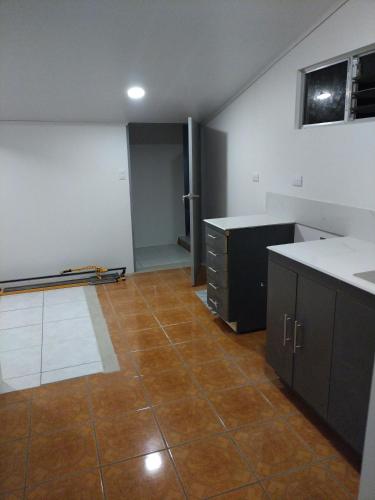 an empty kitchen with a tile floor and cabinets at CONAB in Arenilla