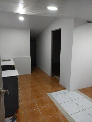 an empty room with white walls and a kitchen at CONAB in Arenilla