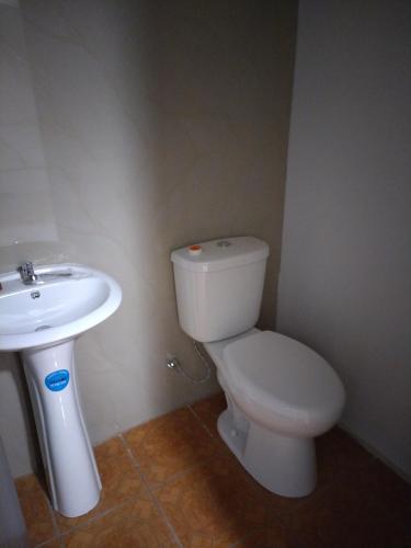 a bathroom with a white toilet and a sink at CONAB in Arenilla