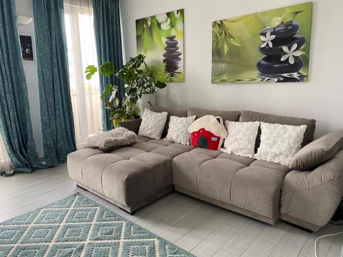 a living room with a brown couch with pillows at Blue light ultracentral in Craiova