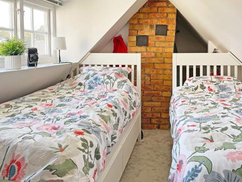 a bedroom with two white beds in a attic at Holiday home SKILLINGE II in Skillinge