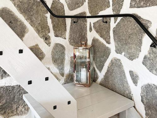 a glass lantern sitting on a table next to a stone wall at Holiday home SKILLINGE II in Skillinge