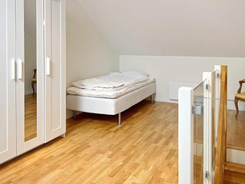 1 dormitorio pequeño con 1 cama y suelo de madera en Holiday home MUNSö, 