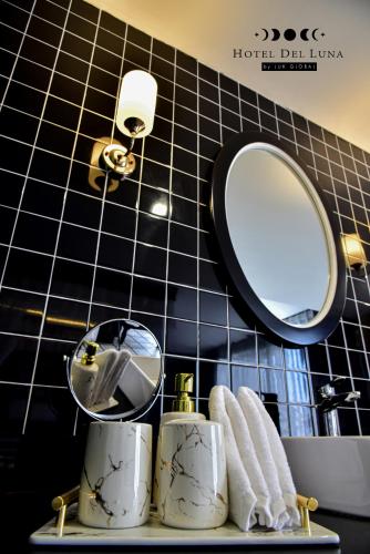 a bathroom with a mirror and towels on a shelf at Hotel Del Luna Boutique in Da Nang