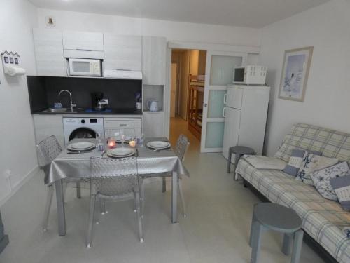 une cuisine et un salon avec une table et un canapé dans l'établissement Notre-Dame-de-Monts - Appartement 48m² - 5 personnes - Garage - Balcon - FR-1-540-217, à Notre-Dame-de-Monts