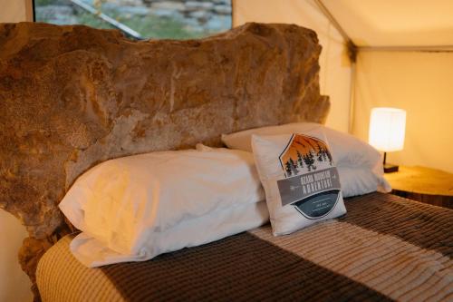 een slaapkamer met een bed met een groot stenen hoofdeinde bij Cozy Unique Glamping on 53 acres - Bedrock Site in Branson