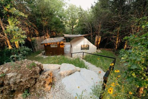 una pequeña casa en medio de un jardín en Cozy Unique Glamping on 53 acres - Bedrock Site en Branson