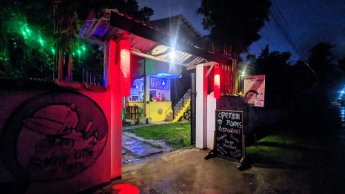 a house lit up at night with red and green lights at Surfing Life in Ahangama
