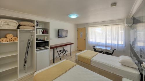 Habitación de hotel con cama y escritorio. en Hotel Corones, en Charleville