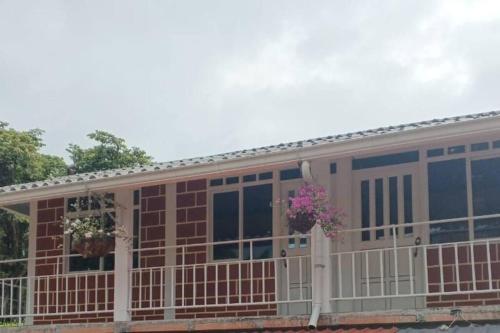 a house with a balcony with flowers on it at La Ramada Campestre in Calarcá
