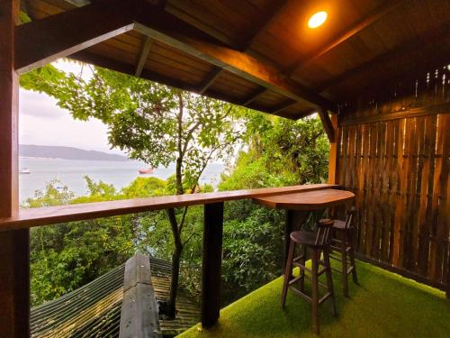 a view from the porch of a cabin with a table and chairs at Paraíso das Tartarugas in Bombinhas