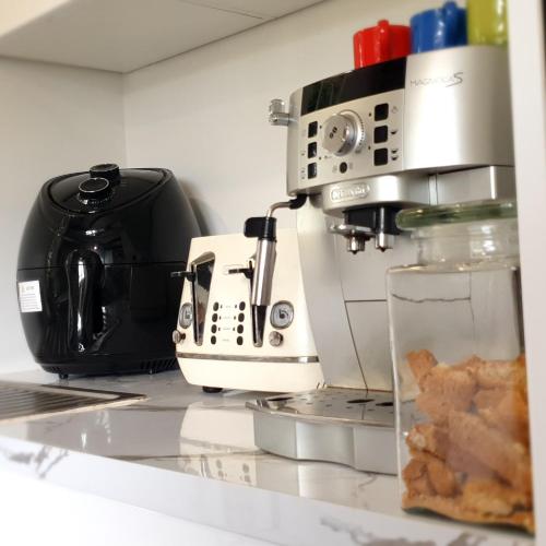 a kitchen counter with a coffee maker and a toaster at Abbeygate Cottage in Auckland
