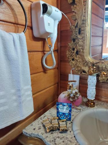 a bathroom with a sink and a phone on a counter at Routemaster in Gramado