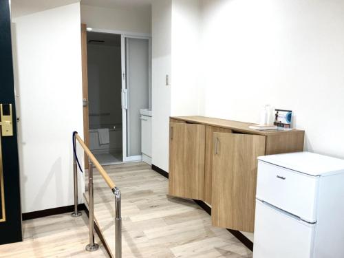 una cucina con armadio in legno e frigorifero di Anan Daiichi Hotel - Vacation STAY 13421v a Anan
