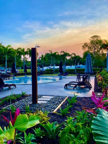 a patio with tables and umbrellas in a park at Bali Hai Child Free Holiday Park Mission Beach in Mission Beach