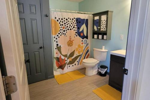 een badkamer met een toilet en een douchegordijn bij Hoosier HideAWAY in Bloomington