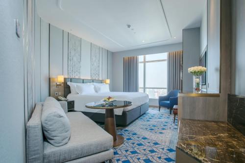 a hotel room with a bed and a couch at Centara Grand At CentralWorld in Bangkok