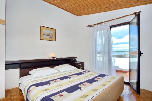 - une chambre avec un lit et une grande fenêtre dans l'établissement Apartment Tkon Rutak, à Tkon