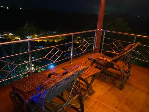 a balcony with two chairs and a table and chairs at Krabi Villa Phu Khao Private Resort in Klong Muang Beach