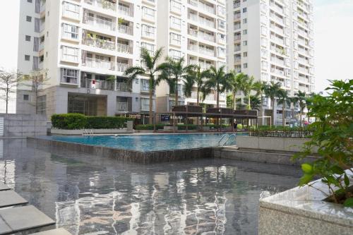 a swimming pool with palm trees and buildings at Apartment Scenic Valley Quận 7 in Ho Chi Minh City