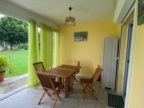 a dining room with a wooden table and chairs at Appartement Les Trois-Ilets, 2 pièces, 2 personnes - FR-1-765-5 in Les Trois-Îlets