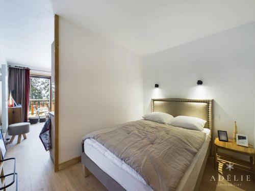 une chambre avec un grand lit et un bureau dans l'établissement Studio Montagne Refait à Neuf, Terrasse Sud, Proche Remontées et Commerces - FR-1-398-660, à Montvalezan