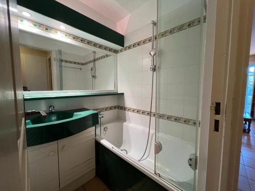 une salle de bain avec une baignoire, un lavabo et un miroir dans l'établissement T2 Charmant avec Piscine et Parking, Proche Hendaye - FR-1-239-1005, à Urrugne