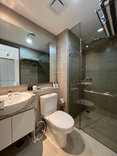 y baño con aseo, lavabo y ducha. en Elegant Mangrove Haven Luxe 1BR at Gold Coast PIK, en Yakarta
