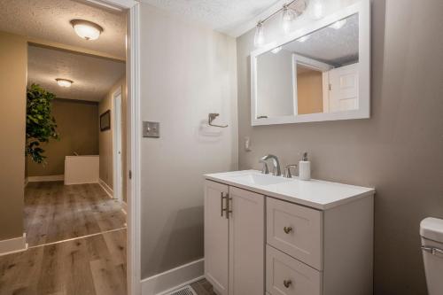 a bathroom with a sink and a mirror at Newly renovated 4BR CozySuites in Louisville