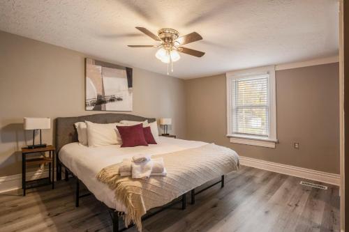 una camera con letto e ventilatore a soffitto di Newly renovated 4BR CozySuites a Louisville