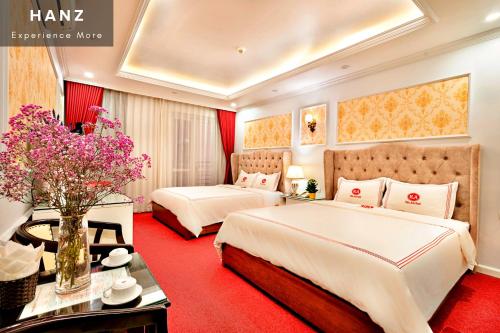 two beds in a hotel room with red carpet at HANZ Kieu Anh Hotel in Hanoi