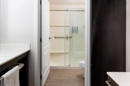 uma casa de banho com uma cabina de duche em vidro e um WC. em Residence Inn Providence Coventry em Spring Lake