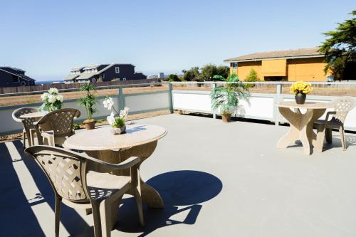 a patio with tables and chairs on a roof at Sea Breeze Inn - San Simeon in San Simeon