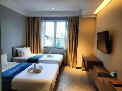 a hotel room with two beds and a television at pristine848 in Manila