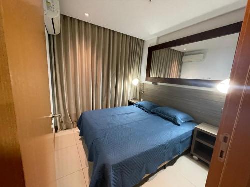um quarto com uma cama azul e um espelho em Samba Rio Convention no Rio de Janeiro