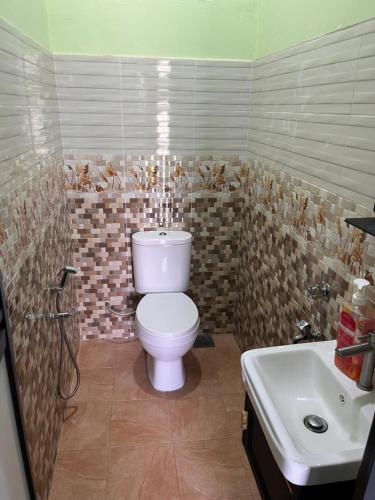 a bathroom with a toilet and a sink at HIJRAH FLEKSI HOMESTAY in Kuala Terengganu