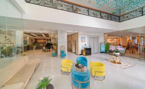 un hall avec des chaises bleues et jaunes dans un bâtiment dans l'établissement Florida Nha Trang Hotel & Spa, à Nha Trang