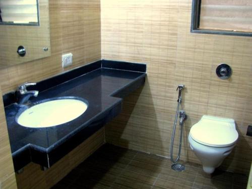 a bathroom with a sink and a toilet at Infinity Lake View Studio in Lavasa